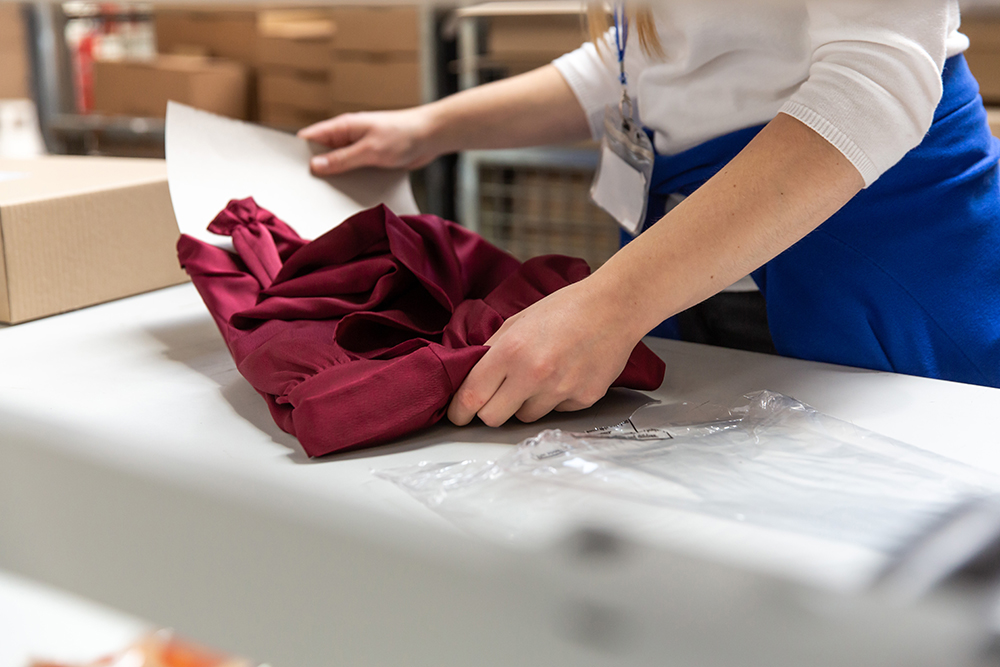 Packaging textile Opératrice préparant un colis textile