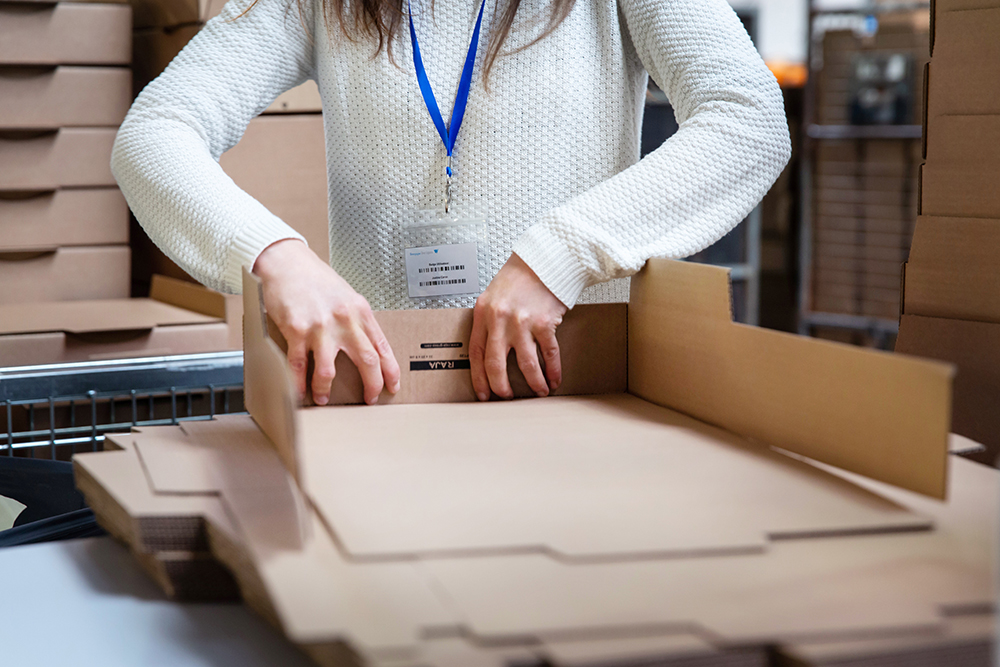 Packaging Une opératrice montant des cartons